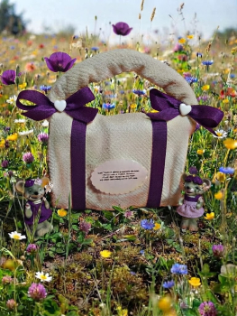 Handgemachte Handtuch-Handtasche in Weiß und Lila, verziert mit lila Schleifen, Herzknöpfen und Geschenk-Stecker mit witzigem Spruch